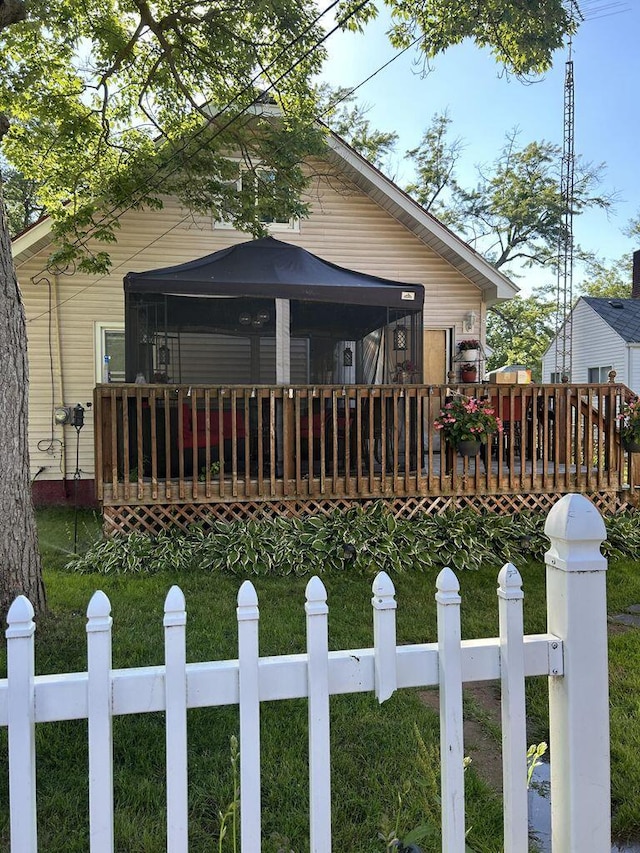 view of front of home with a deck, a gazebo, a front lawn, and a fenced front yard