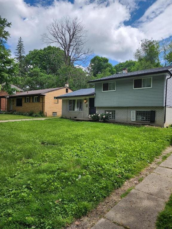 split level home with a chimney and a front yard