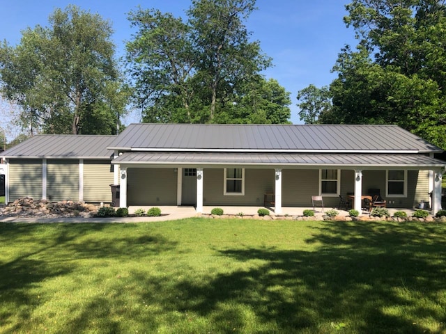 view of front of house featuring metal roof, a standing seam roof, a porch, and a front yard