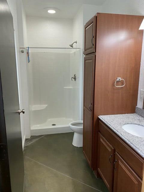 full bathroom featuring toilet, a shower stall, tile patterned flooring, and vanity