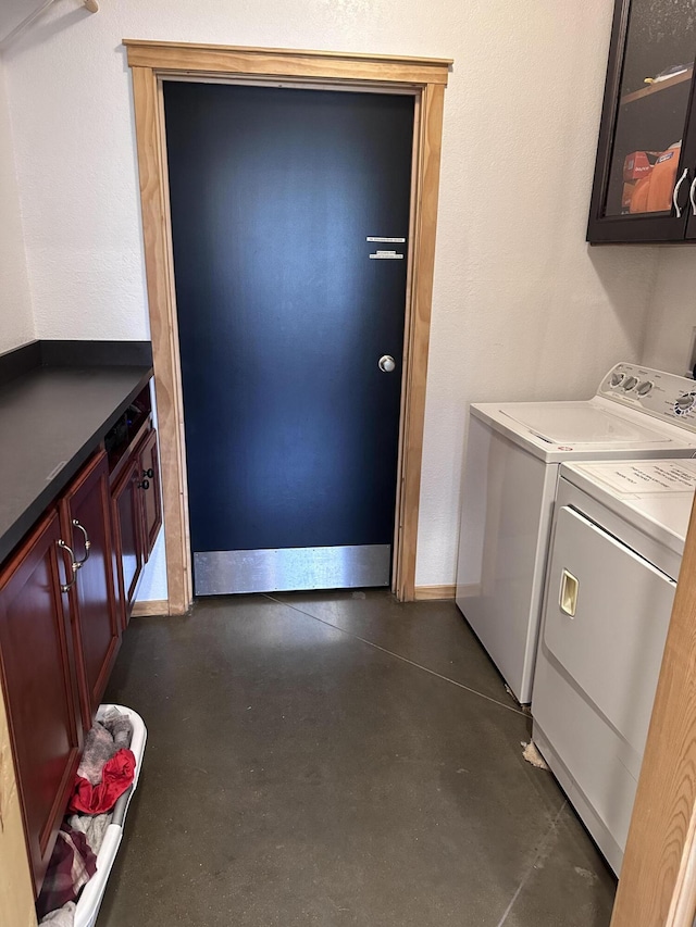 laundry area with baseboards, cabinet space, and washer and dryer