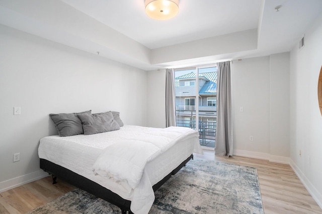 bedroom featuring access to outside, light wood-type flooring, visible vents, and baseboards