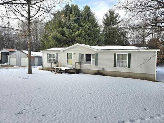 manufactured / mobile home featuring a garage and an outdoor structure