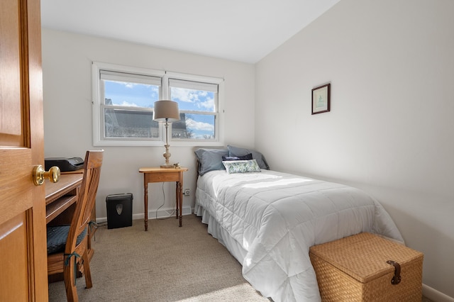 bedroom with baseboards and light colored carpet
