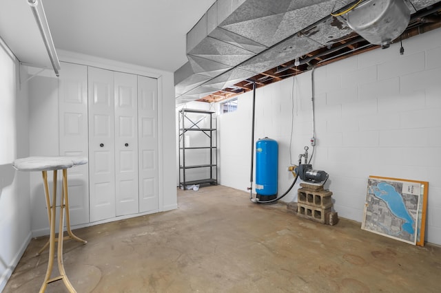unfinished basement featuring concrete block wall