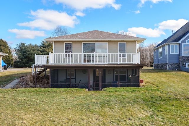 back of house with a sunroom, roof with shingles, a lawn, and a deck