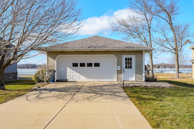 view of front of home with a garage, a front lawn, an outdoor structure, and a water view