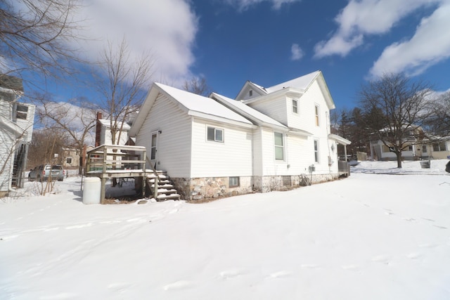 view of snowy exterior featuring a deck and stairway