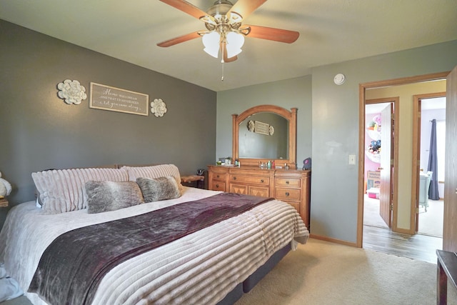 bedroom with a ceiling fan, light carpet, and baseboards