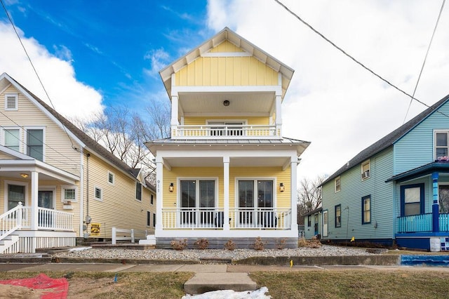 rear view of property with a balcony and a porch