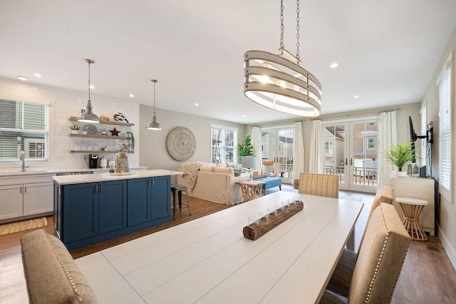 dining room featuring french doors, light wood-style flooring, and recessed lighting