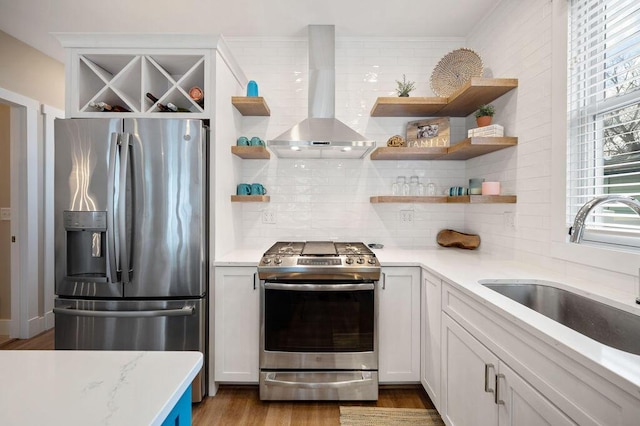 kitchen featuring appliances with stainless steel finishes, white cabinetry, and wall chimney exhaust hood