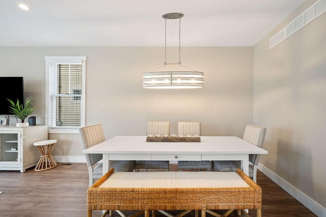 dining room featuring visible vents, baseboards, and wood finished floors