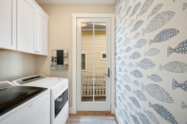 laundry room featuring separate washer and dryer, light wood-type flooring, and cabinet space