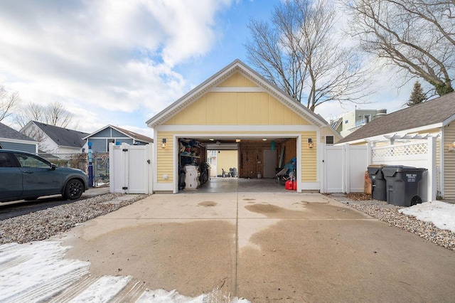 detached garage with a gate and fence