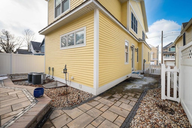 view of home's exterior featuring fence private yard, crawl space, a patio area, and central air condition unit