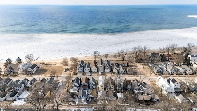 drone / aerial view featuring a water view, a residential view, and a beach view