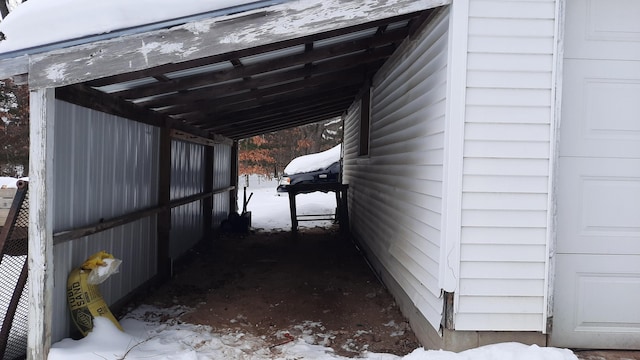 view of snow covered exterior featuring a carport