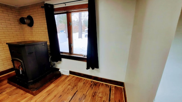 interior space with a wood stove, visible vents, baseboards, and wood finished floors