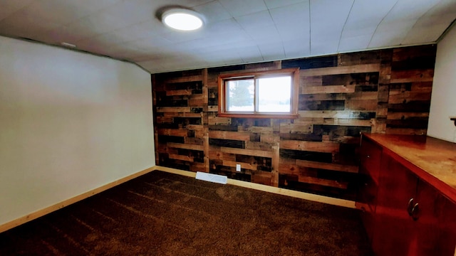 basement with baseboards and wooden walls