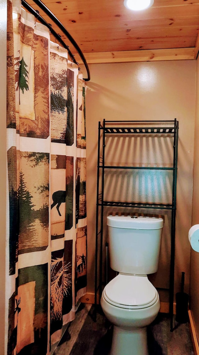 full bath featuring toilet, wooden ceiling, and curtained shower