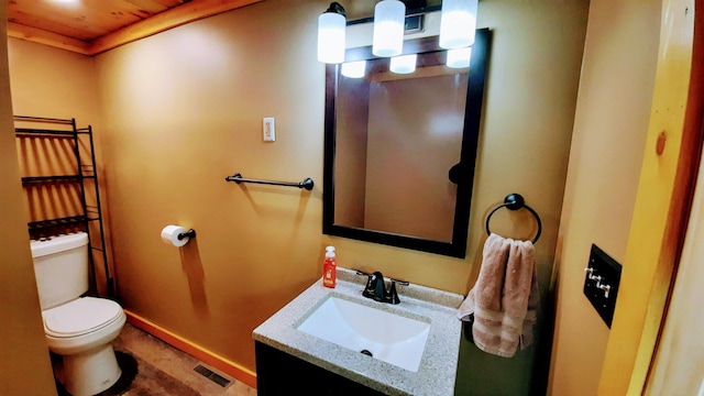 half bathroom with toilet, vanity, visible vents, and baseboards