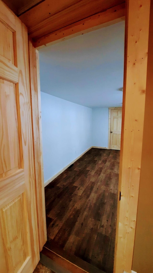 hall featuring dark wood-style floors and baseboards