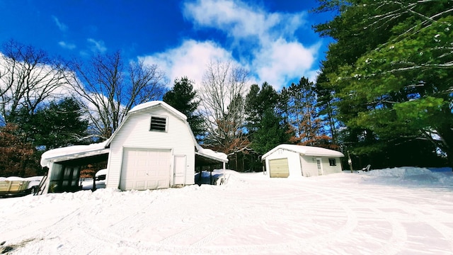 snow covered garage with a detached garage