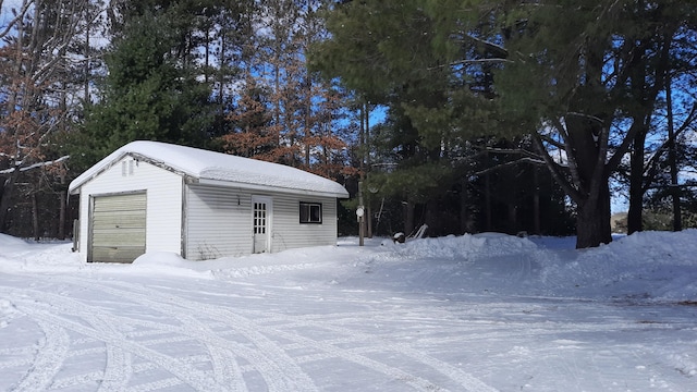 snow covered garage featuring a garage