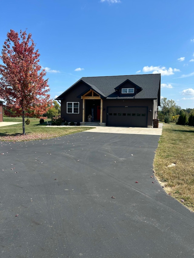 view of front of property featuring a front yard, driveway, and an attached garage