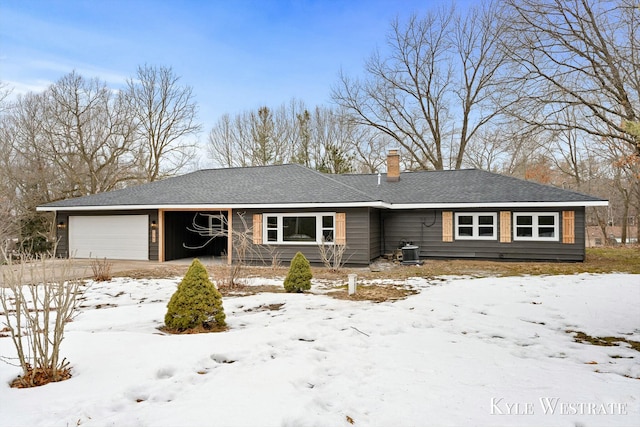 ranch-style home featuring a garage, central AC, a chimney, and roof with shingles