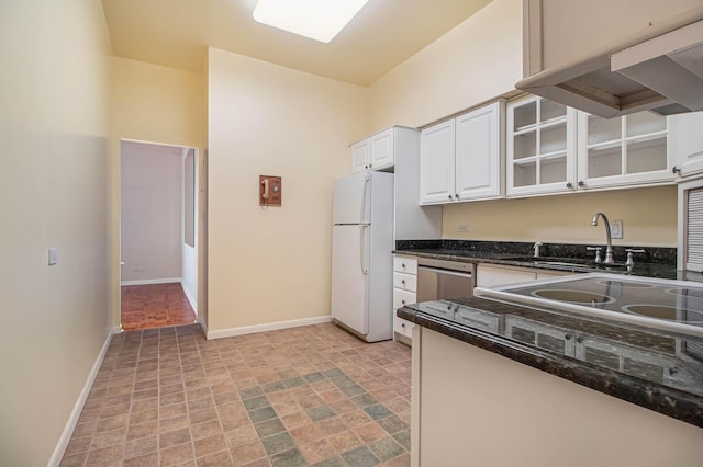 kitchen featuring under cabinet range hood, a sink, white cabinets, stainless steel dishwasher, and freestanding refrigerator