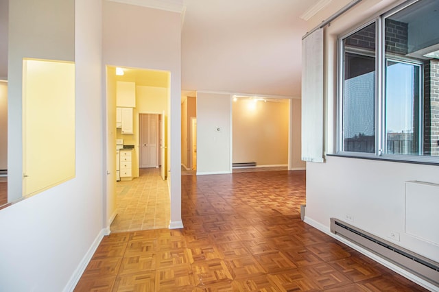 hallway featuring a towering ceiling, baseboards, a baseboard heating unit, and baseboard heating