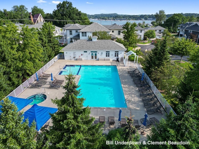 community pool featuring french doors, a patio area, fence private yard, and a residential view