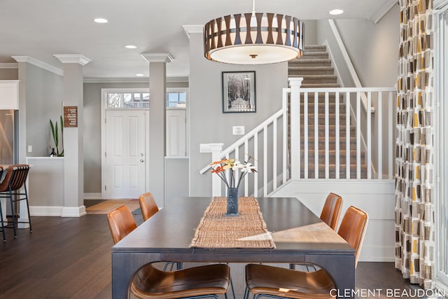dining room featuring dark wood-style flooring, baseboards, stairs, ornamental molding, and decorative columns