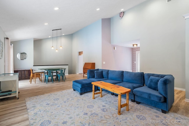 living room with light wood finished floors, baseboards, high vaulted ceiling, and recessed lighting