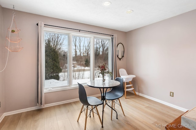 dining area featuring light wood-style floors, plenty of natural light, and baseboards