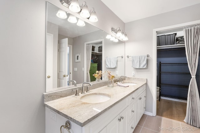 bathroom with double vanity, baseboards, and a sink