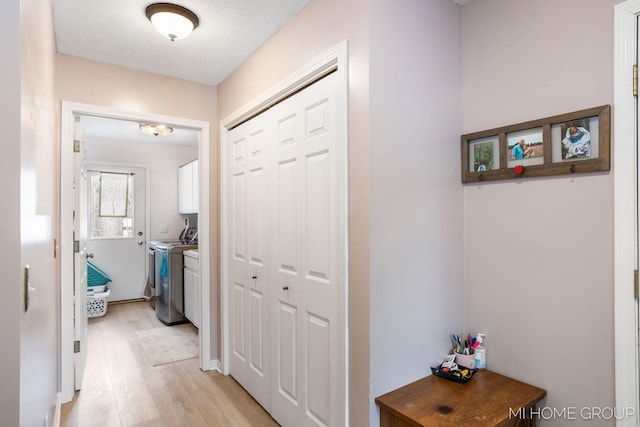 hallway featuring light wood-type flooring and washer and clothes dryer