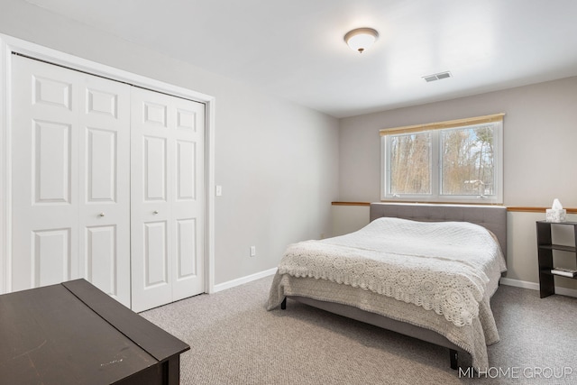 bedroom featuring a closet, baseboards, visible vents, and carpet flooring