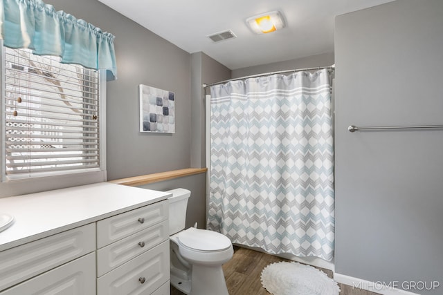 full bathroom with visible vents, toilet, vanity, wood finished floors, and a shower with curtain