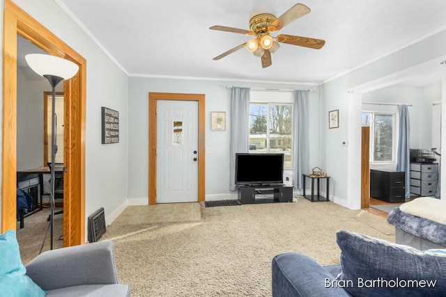 carpeted living room with baseboards, visible vents, ornamental molding, and ceiling fan