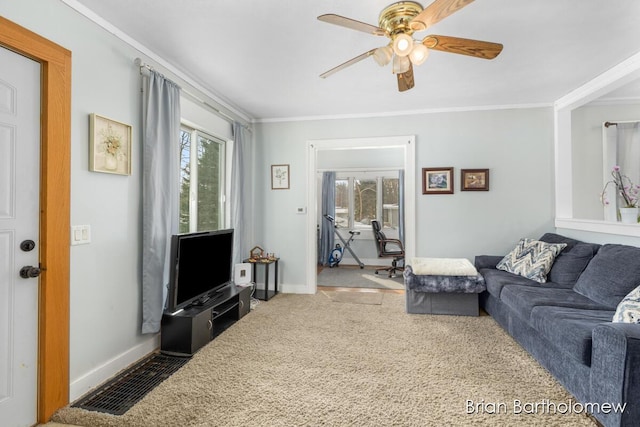 carpeted living area with ornamental molding, plenty of natural light, and baseboards