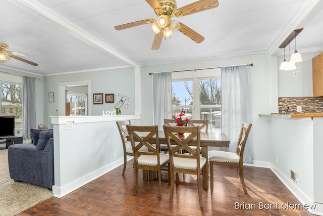 dining area with baseboards, visible vents, dark wood-style floors, ceiling fan, and crown molding