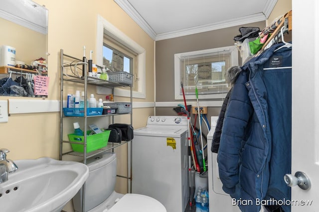 bathroom with toilet, washer / clothes dryer, a sink, and ornamental molding