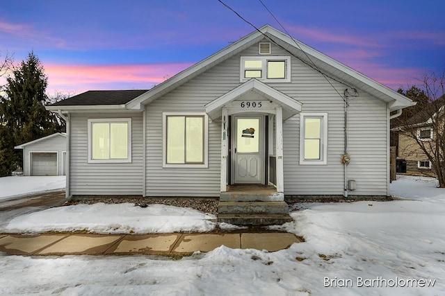 bungalow-style house featuring an outbuilding and a detached garage