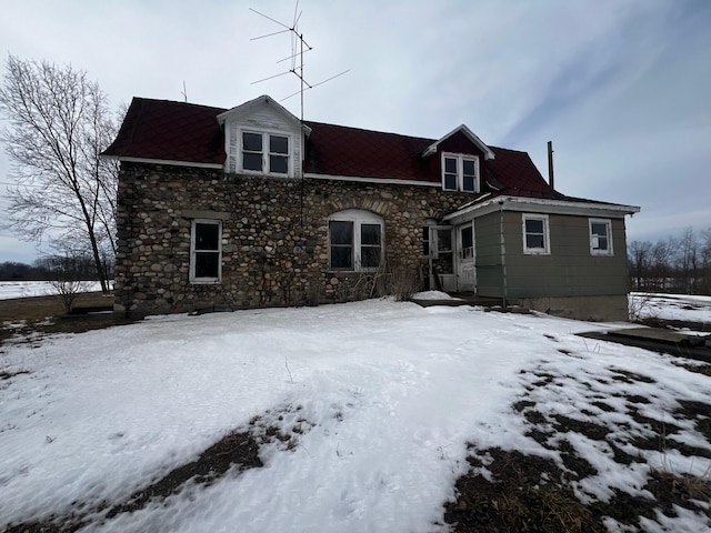 view of snow covered rear of property