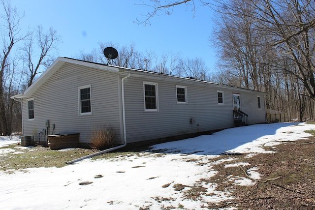 snow covered property featuring cooling unit