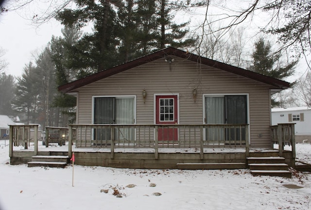 snow covered property with a wooden deck