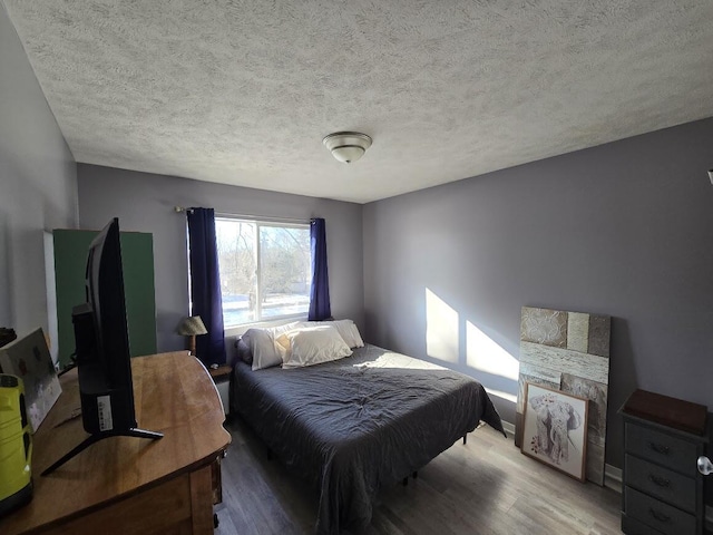 bedroom featuring a textured ceiling and wood finished floors